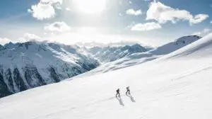 Sustainable Skiing ski tourers walking up the piste in the snowy mountains