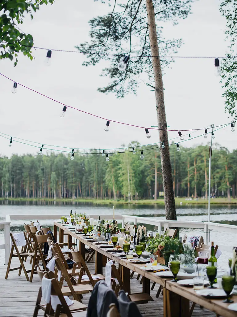 Table laid up outside for a party next to a lake showing an example of sustainable celebrations