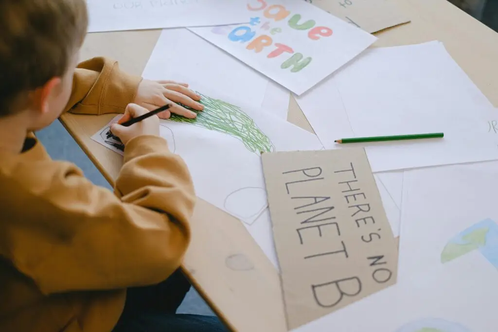 A child colouring images of the earth and the slogan "There is no Planet B" showing education on sustainability and climate change.