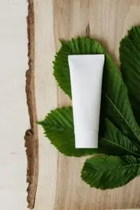 White shower gel with no branding lying on a leaf to show eco beauty products