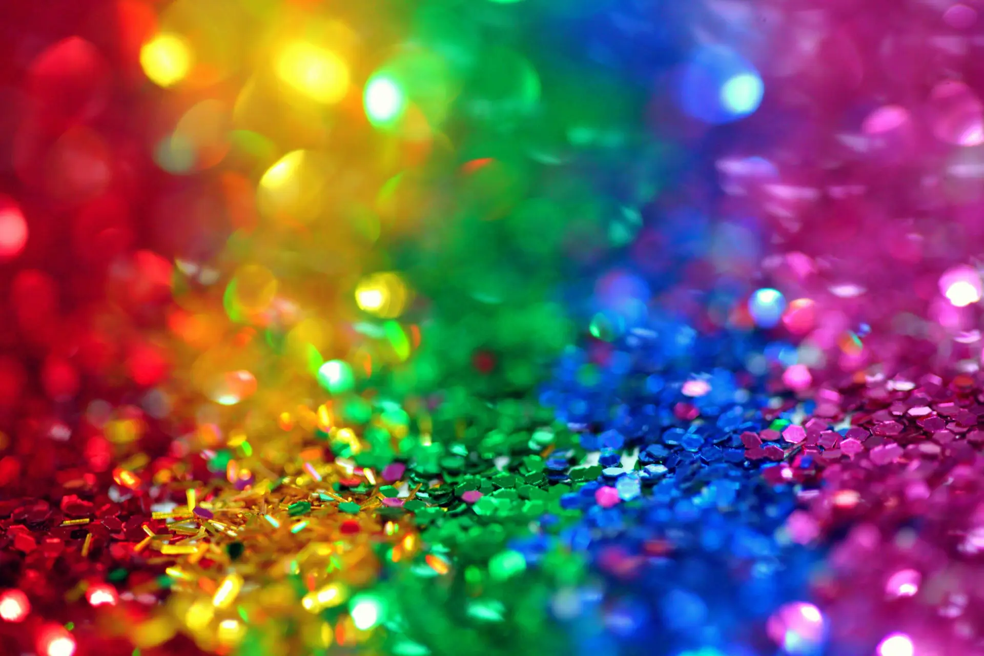 Layers of glitter in different colours: red, yellow, green, blue and purple.